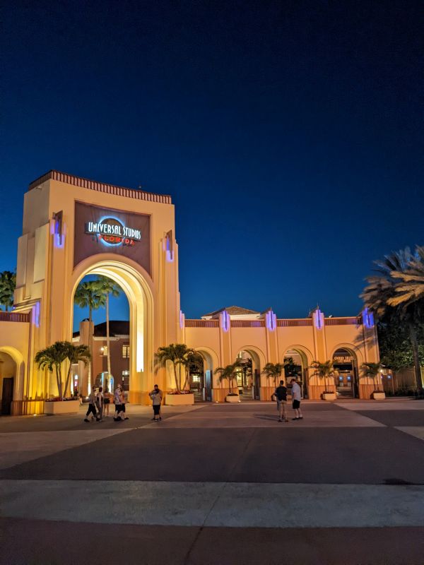 Universal Studios Orlando Arch Entrance at night.  The arch is lit up.