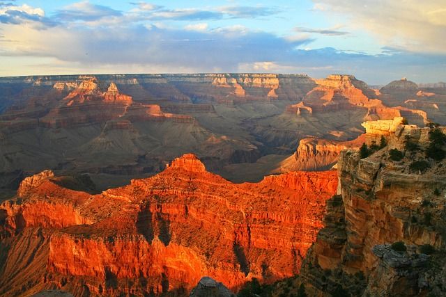 A photo of the grandeur of the Grand Canyon at Sunset.  The rocks look like they are glowing with the setting sun.