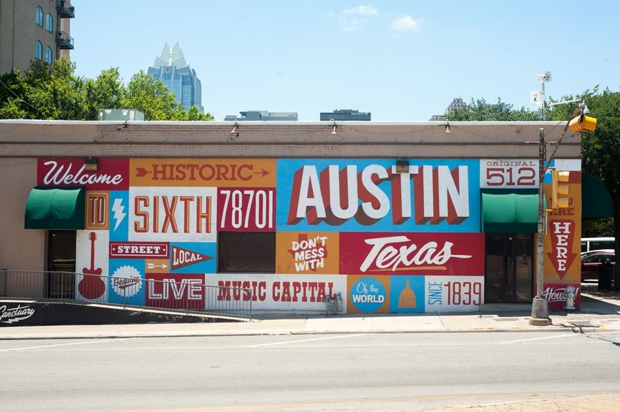 A historic mural in Austin Texas.  The Mural consists of colorful squares with different words in the about Austin in varying fonts.
